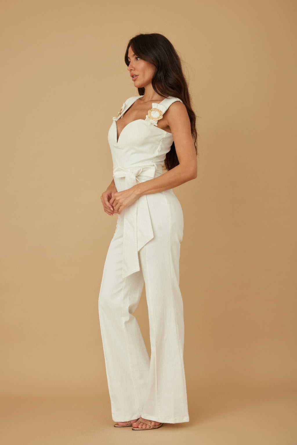 White strap jumpsuit with intertwined gold ring embellishments on the shoulders