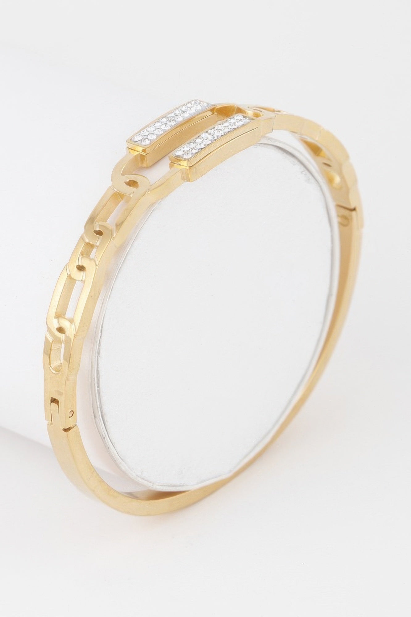 Gold hinged curb chain bracelet with clear stone row on the clasp