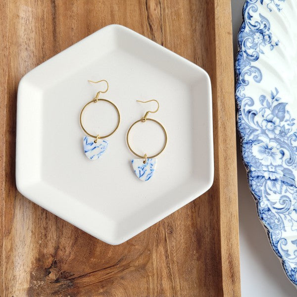Pair of gold hoop earrings with blue patterned teardrop charms