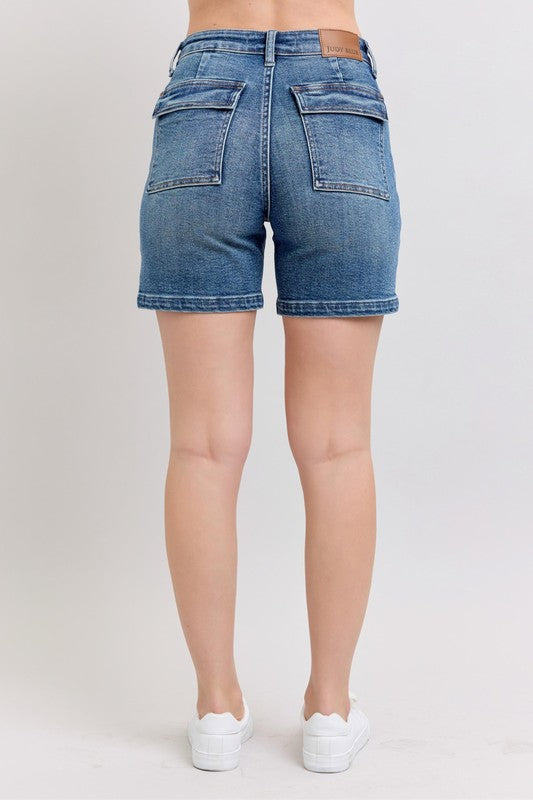 Back view of medium-wash high-rise denim shorts with two back patch pockets
