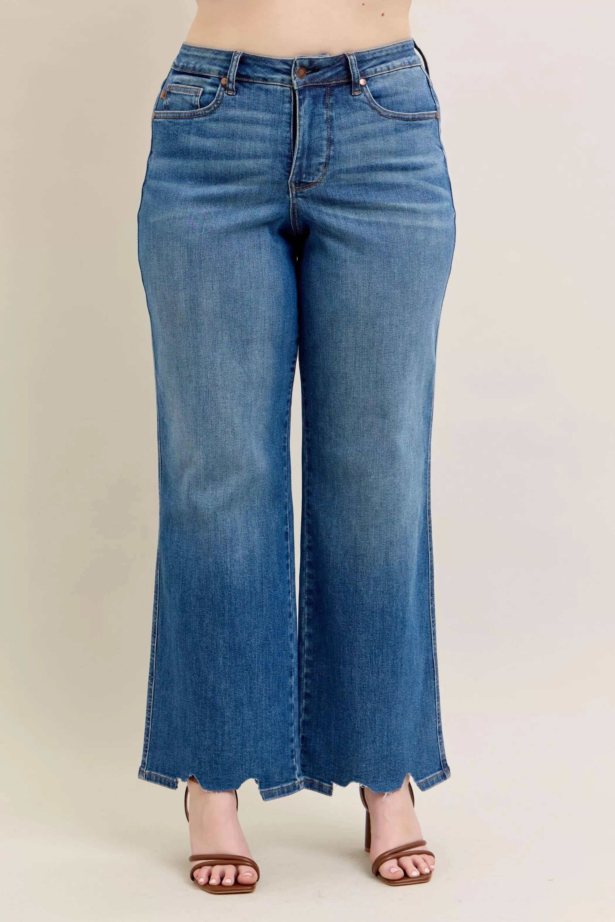Mid-wash high-waist wide-leg jeans with torn “chew” style hem detail