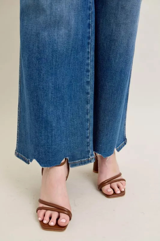Mid-wash high-waist wide-leg jeans with uneven torn hem and straight side seam