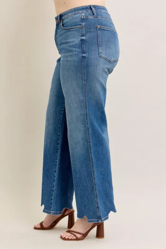 Side view of mid-wash high-waist wide-leg jeans with destroyed hem and stitching