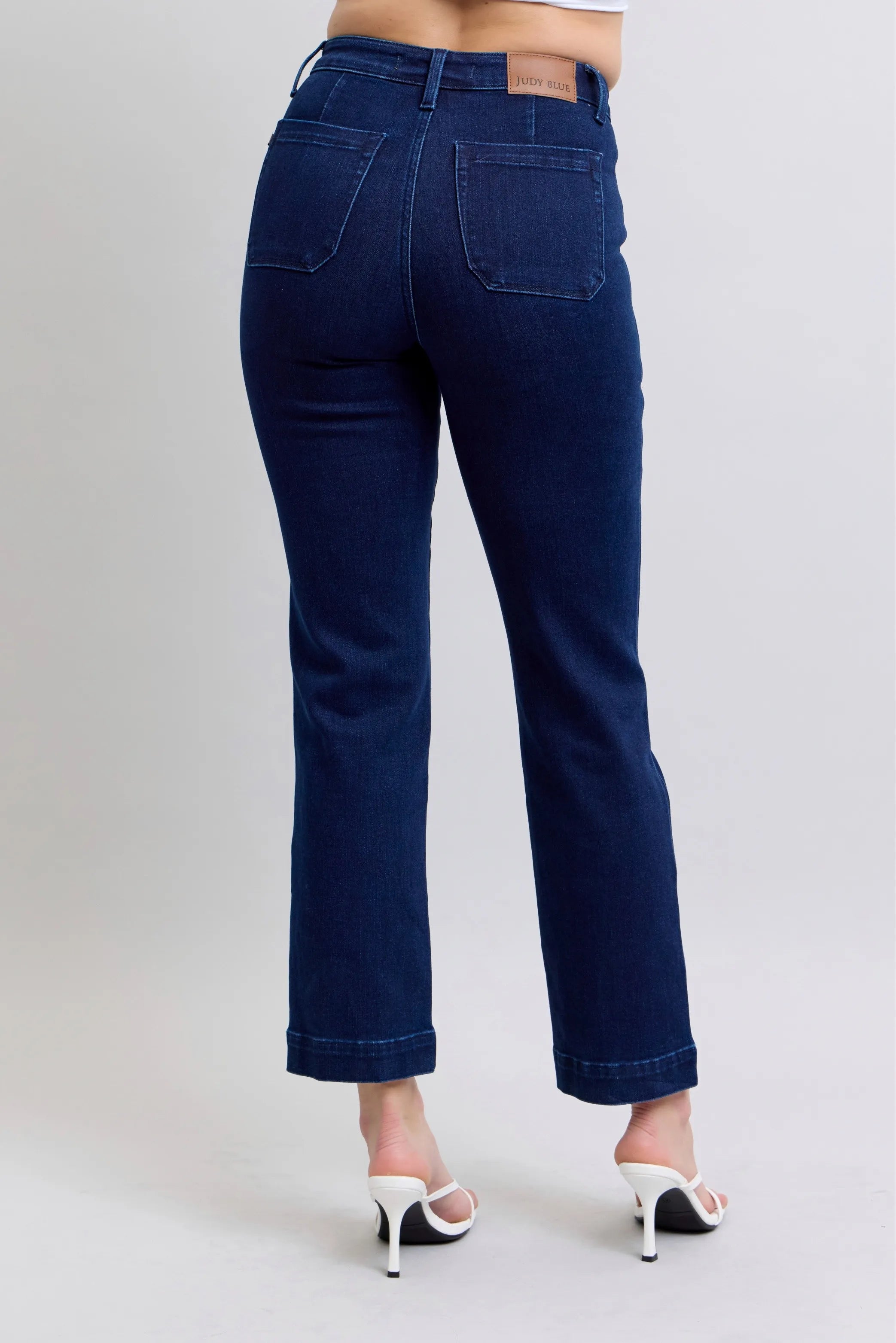 Dark blue straight jeans with knee patches, front/back pockets, belt loops.