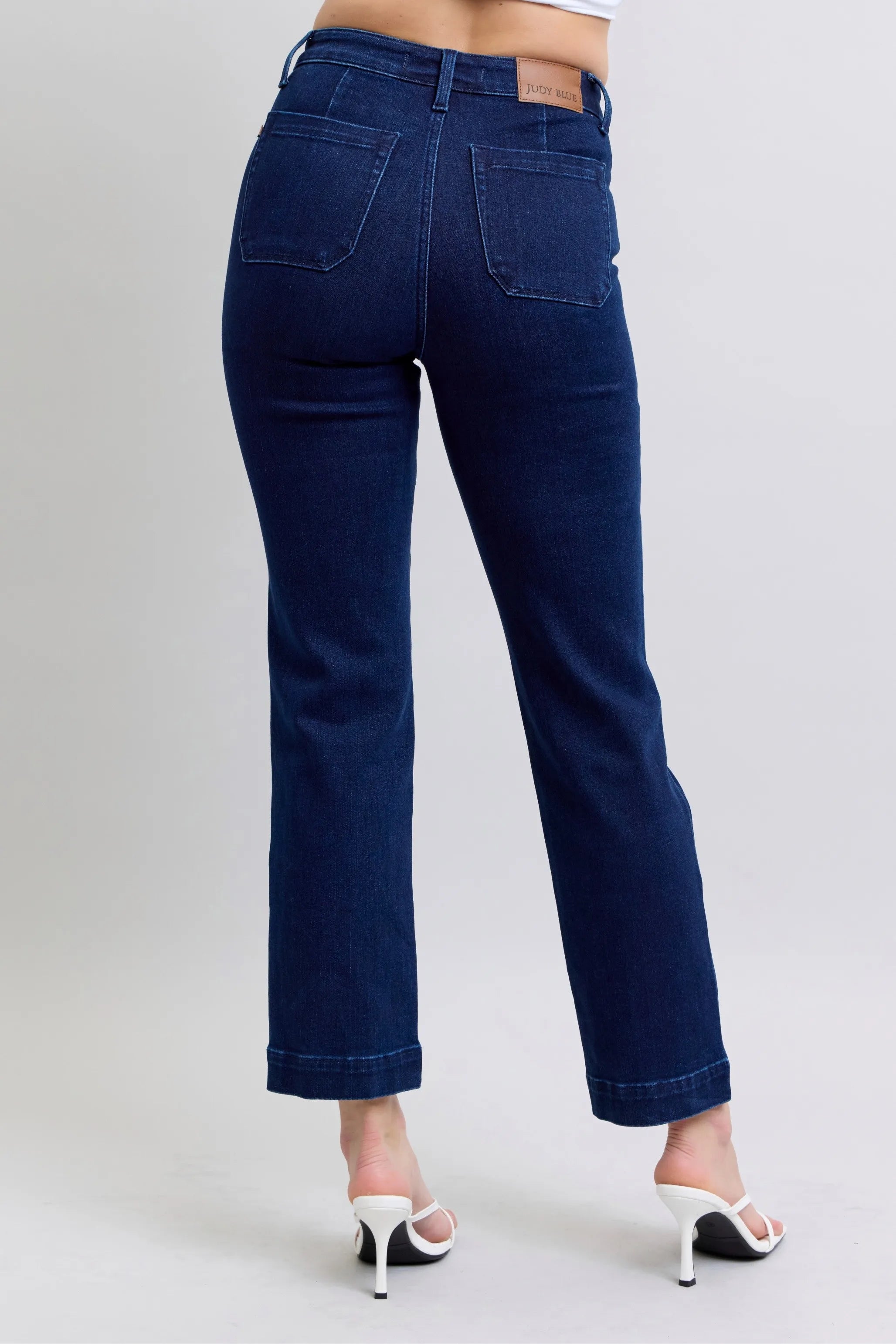 Dark blue straight jeans, back view with two back pockets and patched hems.