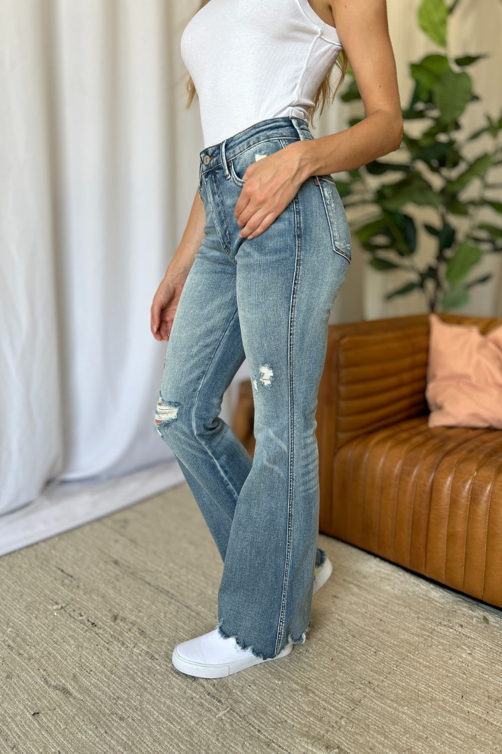 Medium-wash straight-to-flare jeans with button fly, ripped thigh and frayed cuffs