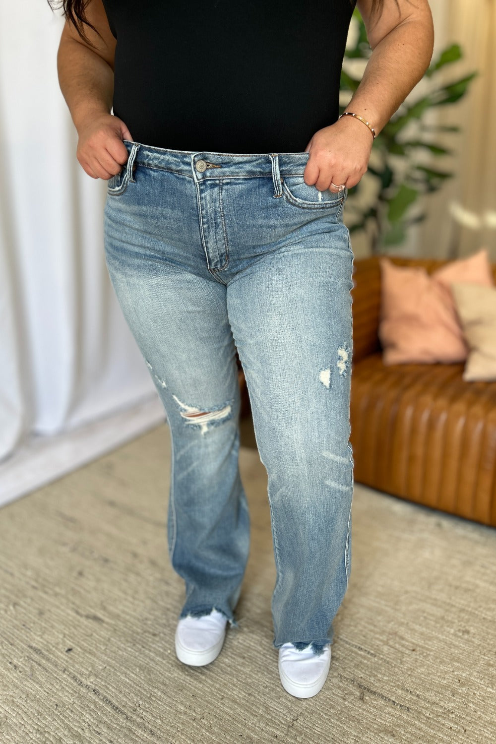 Light-wash mid-rise jeans with ripped front knees and distressed back view