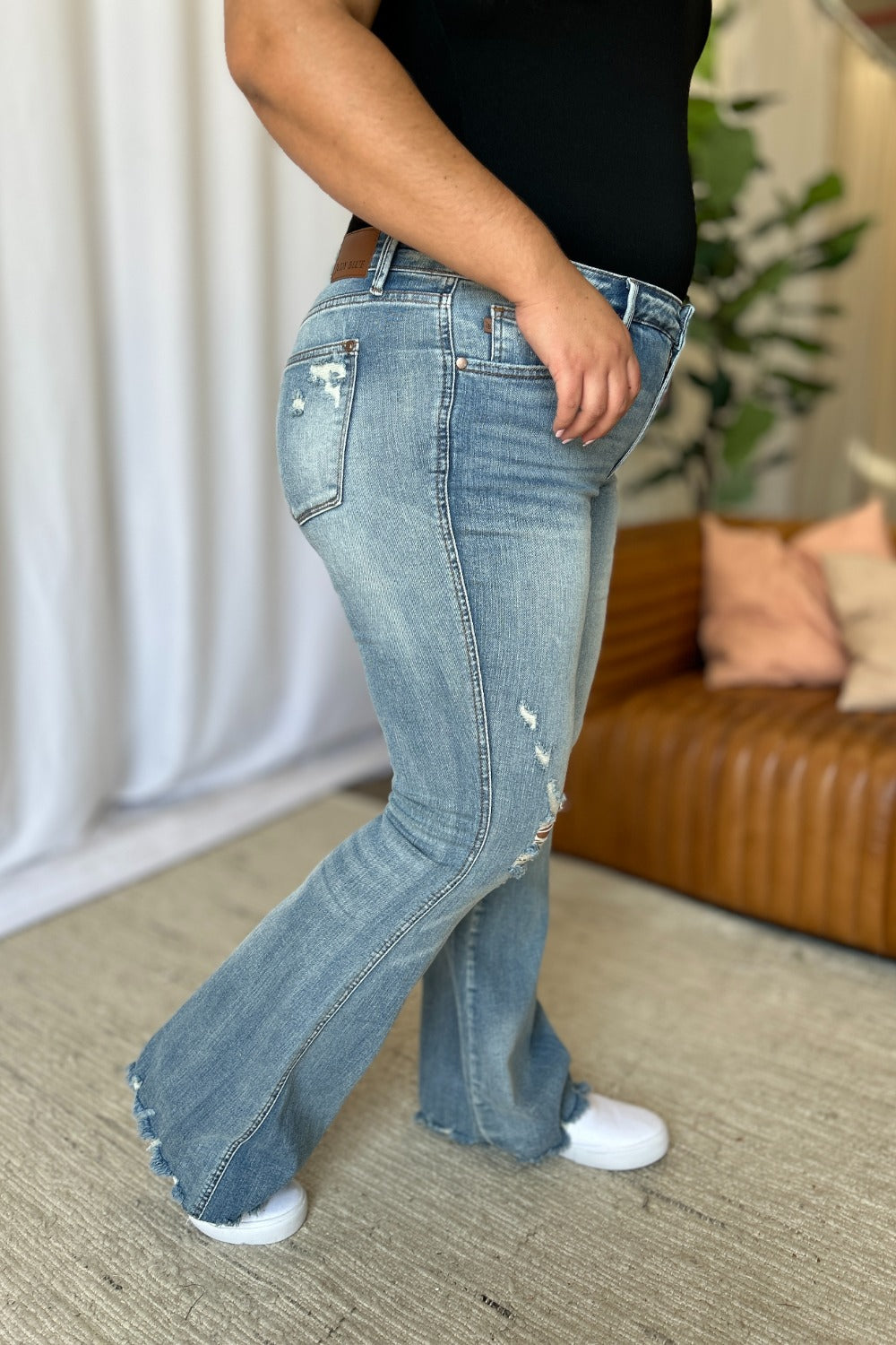 Light-wash flare jeans with side seam distress and raw frayed bottom hem