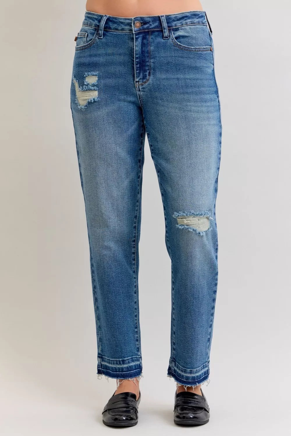 Medium blue mid-rise jeans with front and knee rips, release hem frayed cuffs