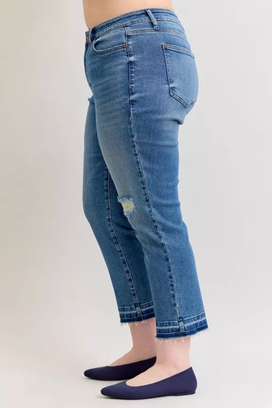 Side view medium-wash boyfriend jeans with ripped patch and frayed release hem