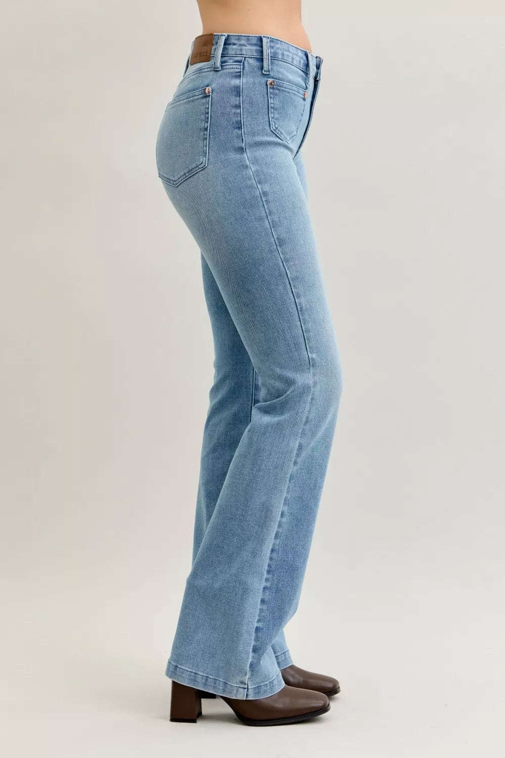 Light blue mid-rise bootcut jeans, side view, contrast wash and stitched details