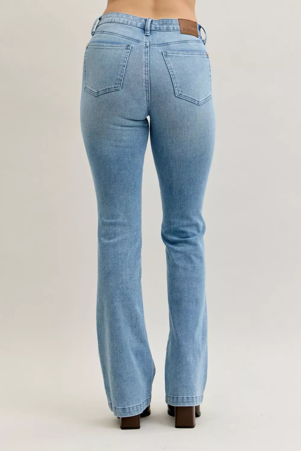 Light blue mid-rise bootcut jeans, back view, center seam and contrast wash