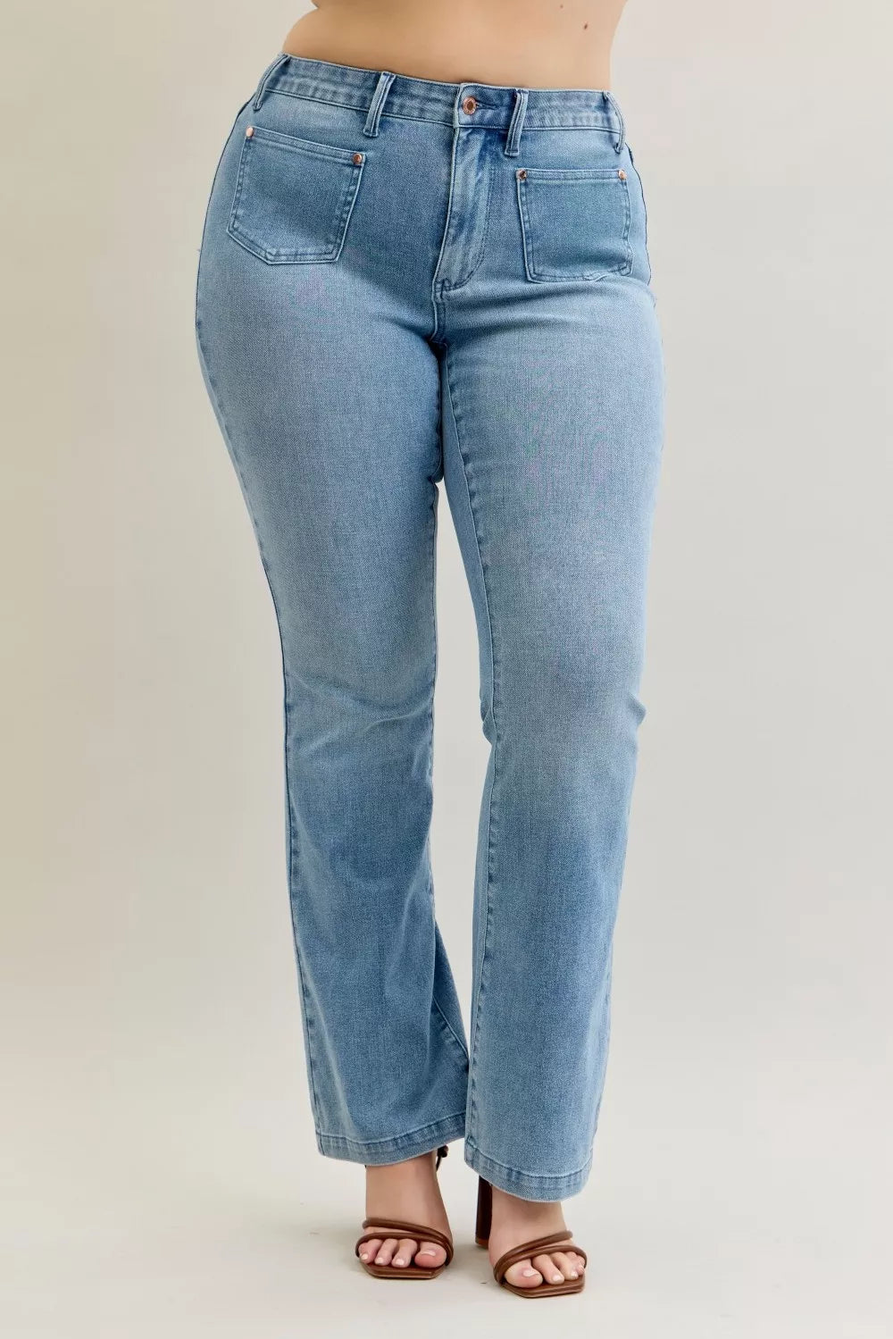 Medium-dark wash mid-rise bootcut jeans with front patch pockets and curved yoke