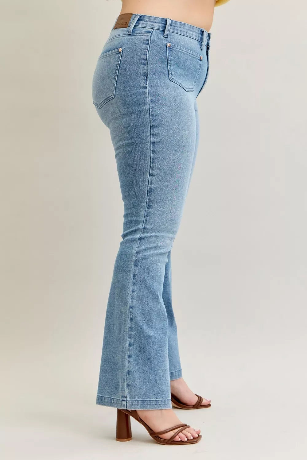 Side view medium-dark wash bootcut jeans with front fly and patch pocket