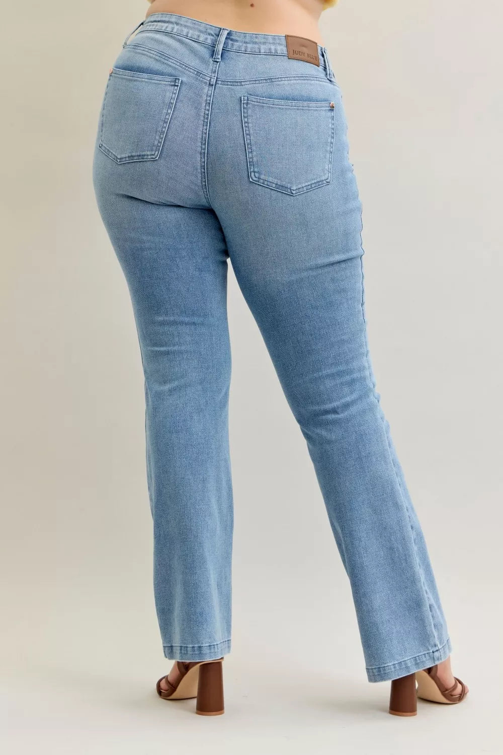 Medium-dark wash mid-rise bootcut jeans, back pockets and waistband logo patch