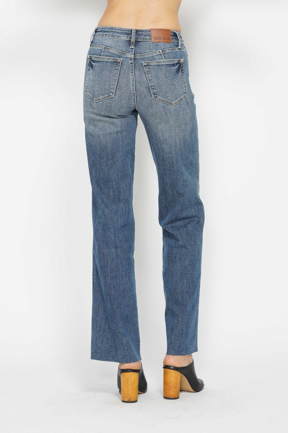 Medium-wash straight jeans, back close-up with yoke seams and waistband label