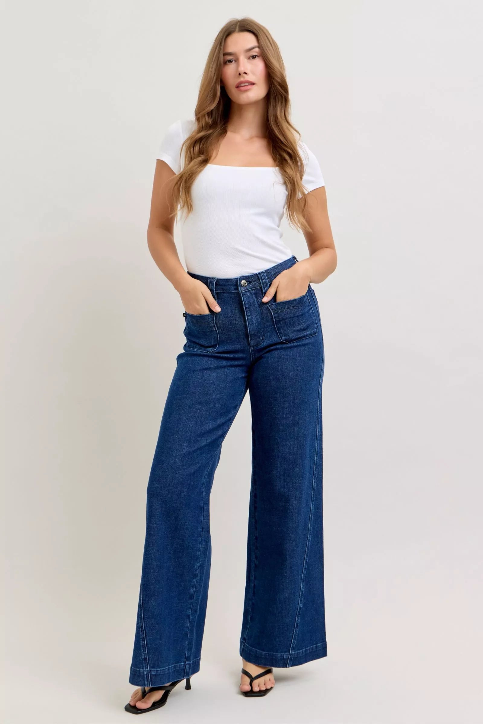 High-waisted wide-leg jeans, dark wash, patch pockets, twisted seams