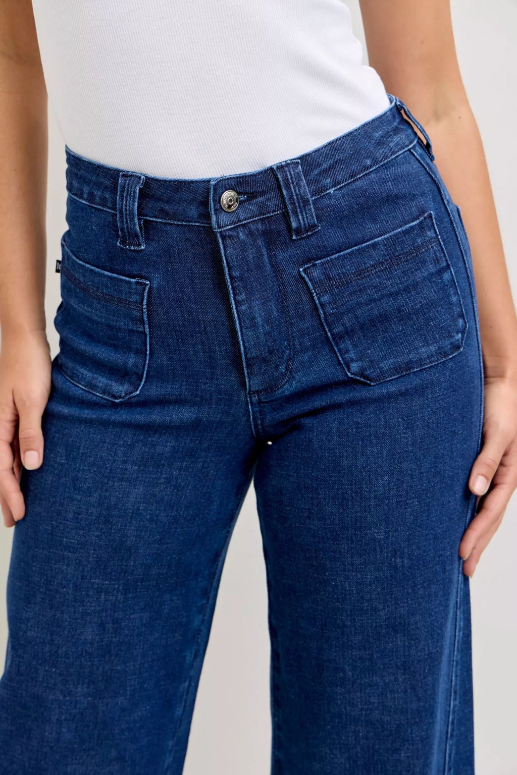 Dark-wash high-waisted jeans, button waistband and front patch pockets