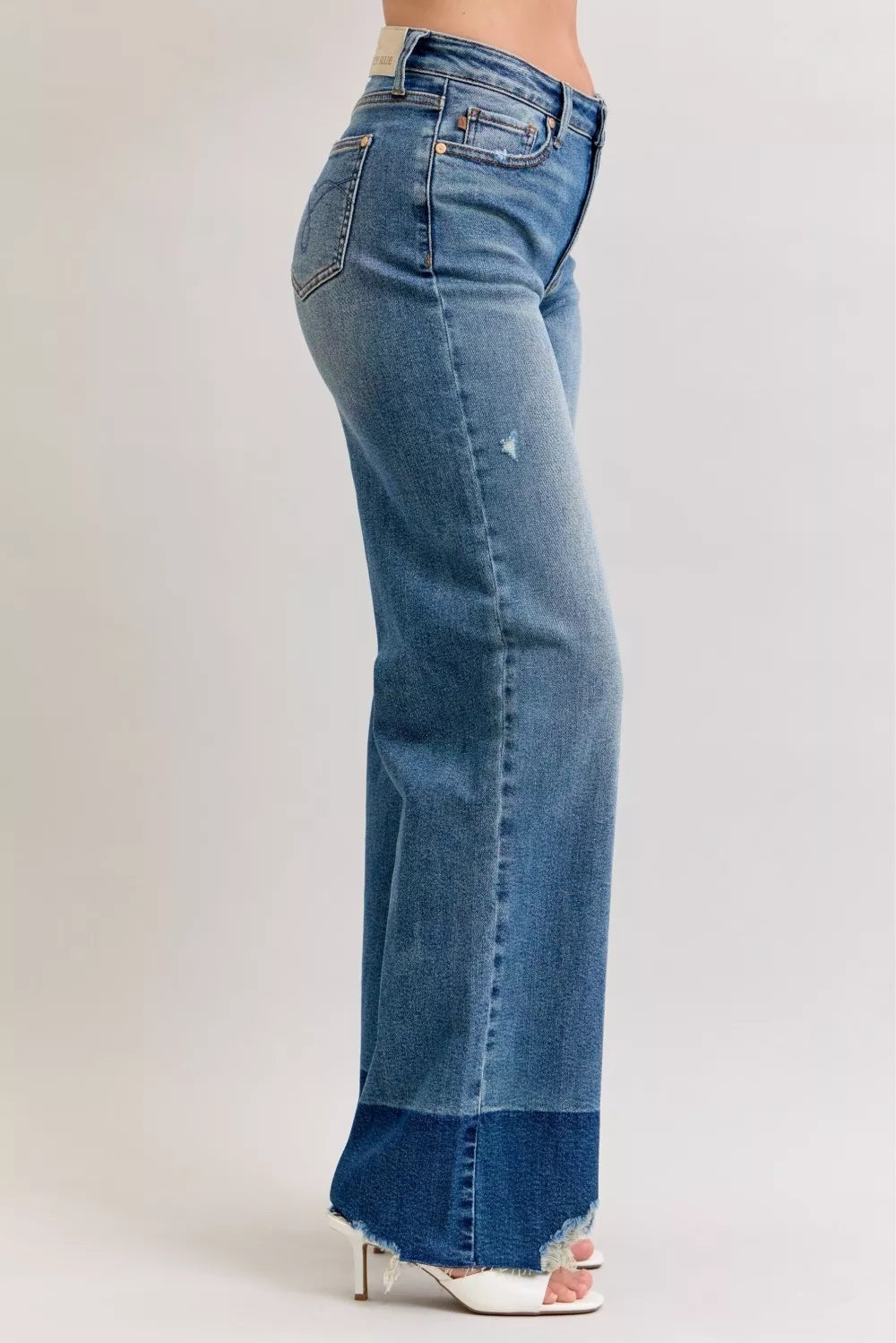 Dark wash (DK) straight jeans with raw hem, side view and back yoke