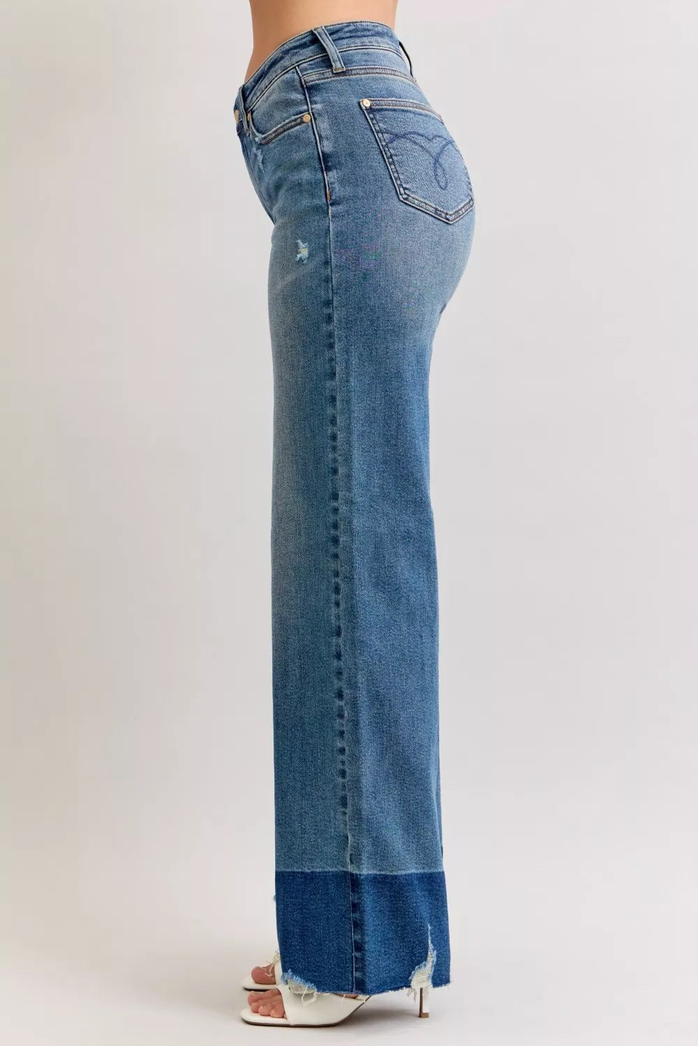 Dark wash (DK) straight jeans, side back view with raw hem detail