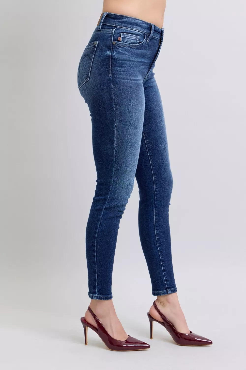 Dark blue skinny jeans, side view with sleek tapered leg and back pocket seams