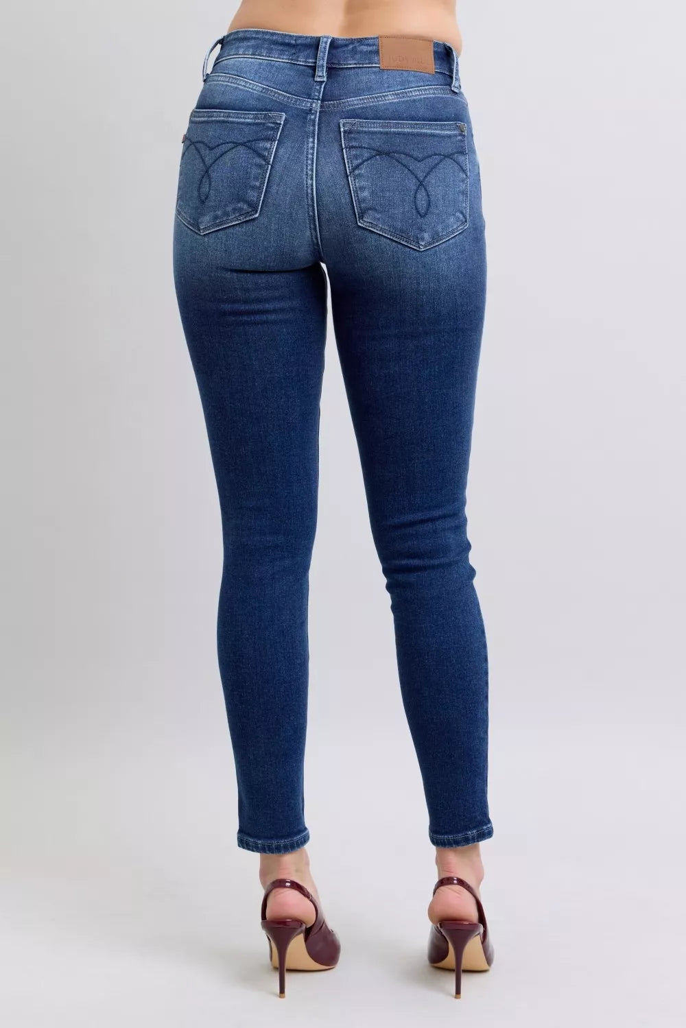 Dark blue skinny jeans with stitched back pockets and tapered ankle