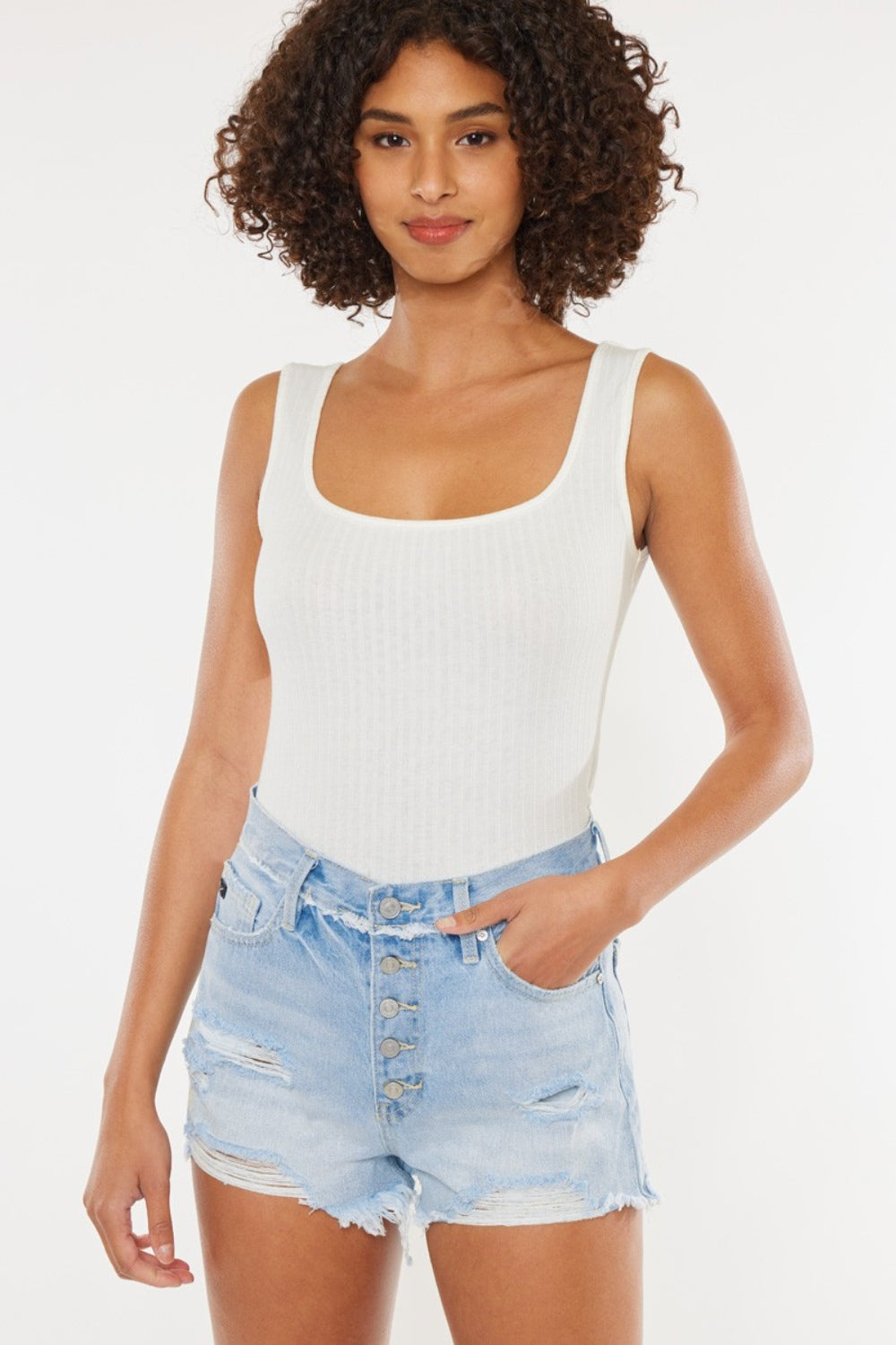 Distressed button-fly denim shorts en azul medio, tiro alto, dobladillo deshilachado