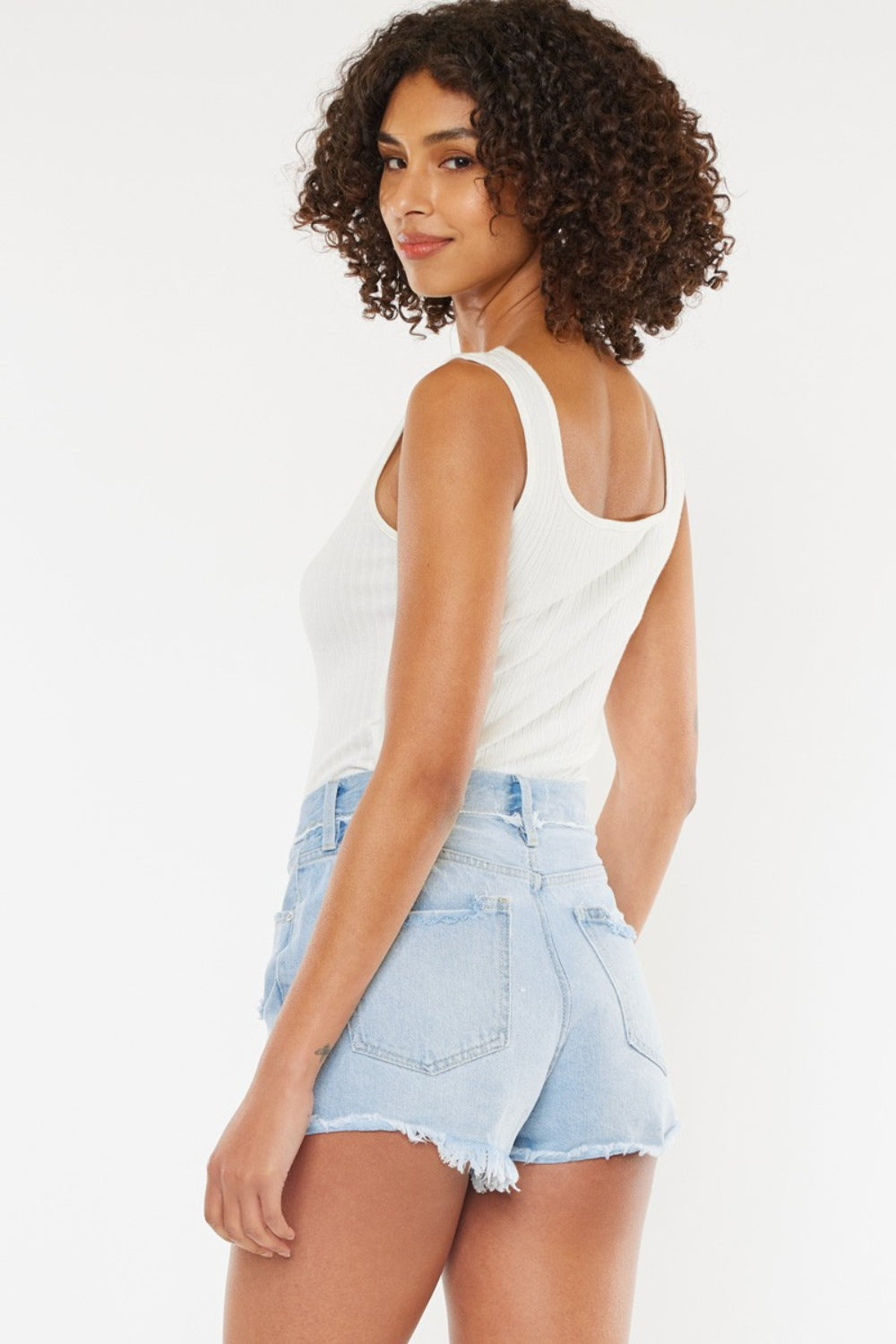 Shorts de mezclilla azul medio con botones en la bragueta y bordes deshilachados