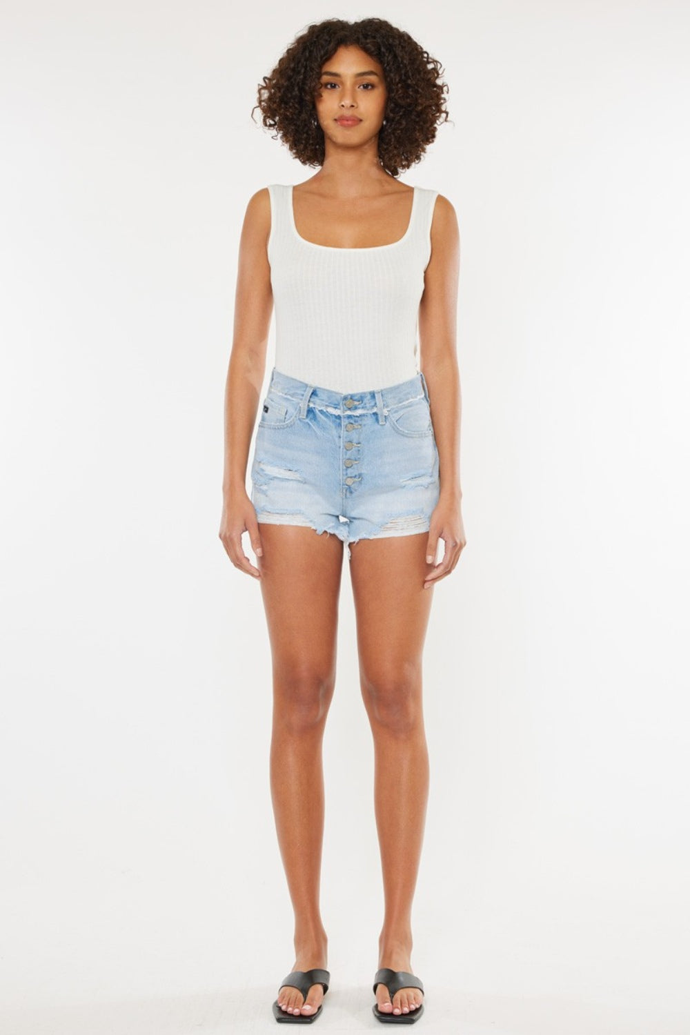 Shorts de denim azul medio con bragueta de botones y desgaste en los muslos