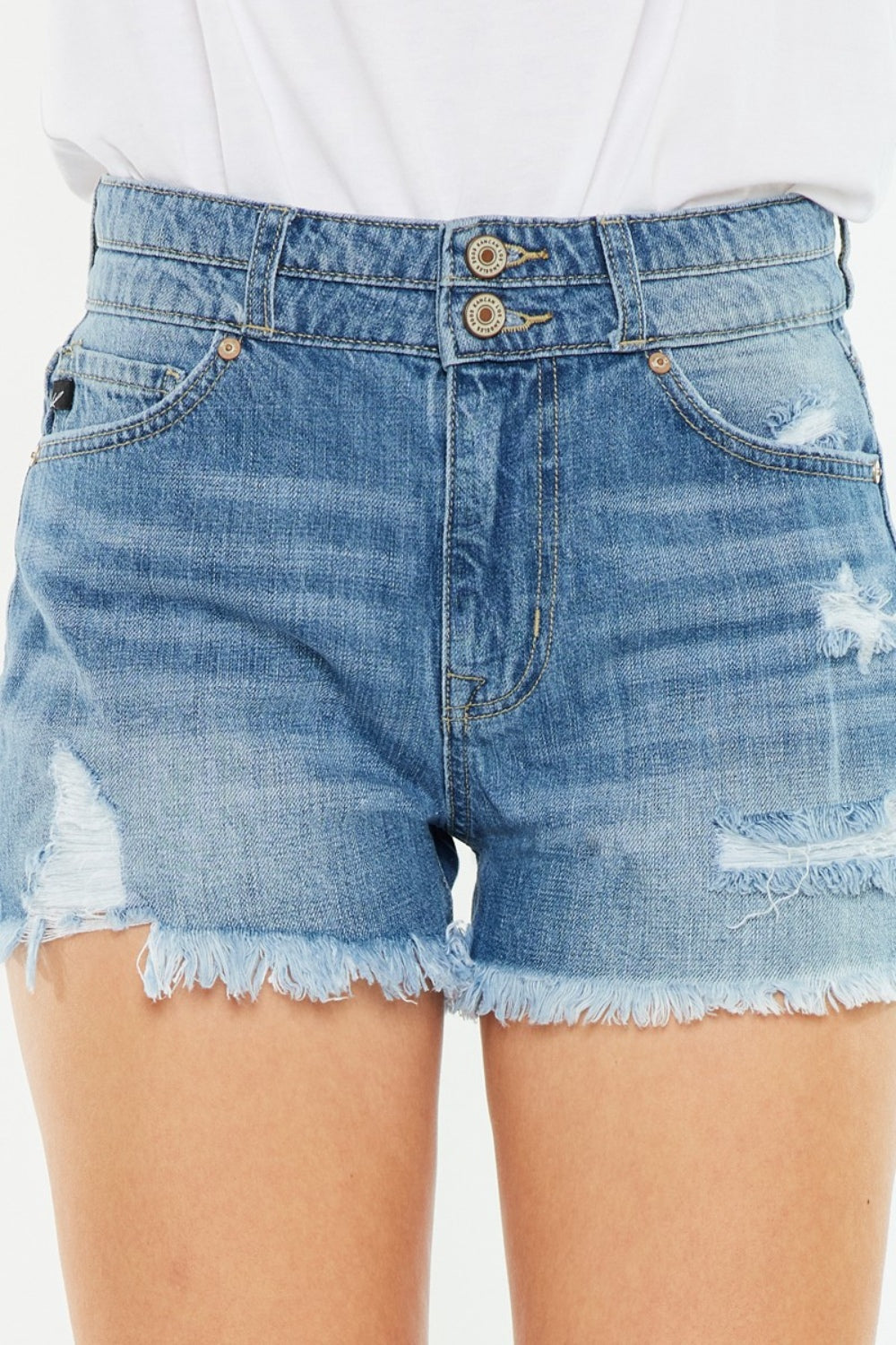 High-rise denim shorts waistband close-up with double-button detail and frayed hem