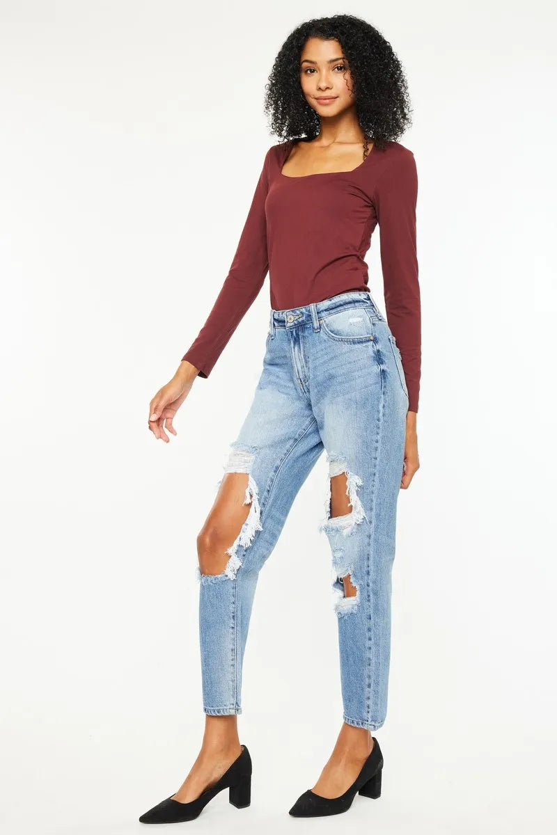 Medium wash high-rise boyfriend jeans with stacked rips at thighs and knees, cropped length