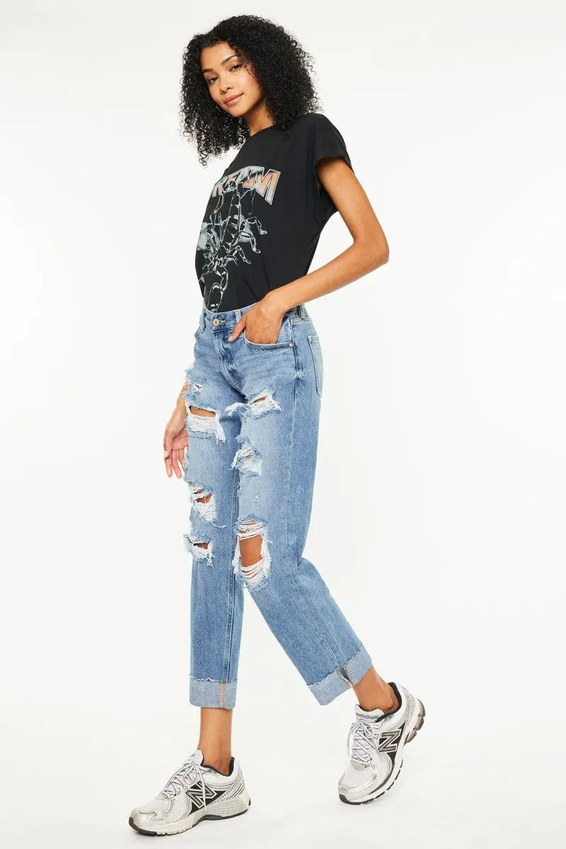 Medium-wash distressed boyfriend jeans, cropped length with tear details