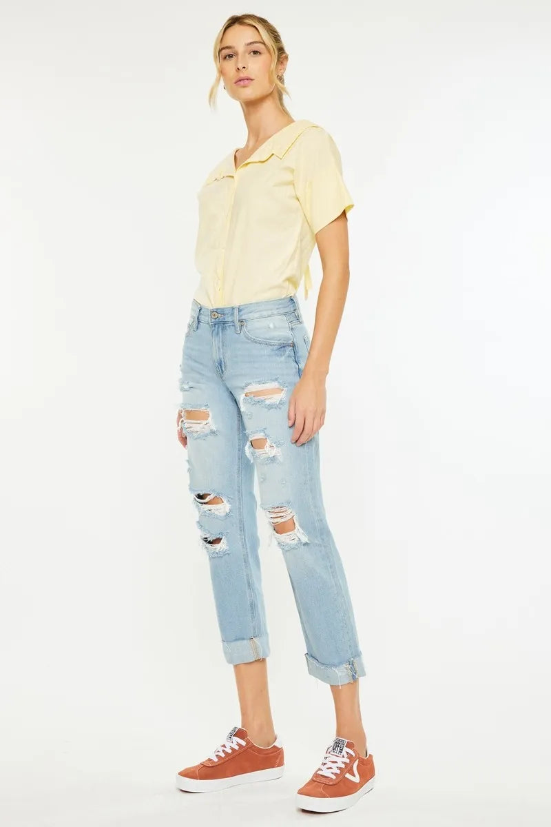 Light wash mid-rise boyfriend jeans with multiple knee rips and rolled hem