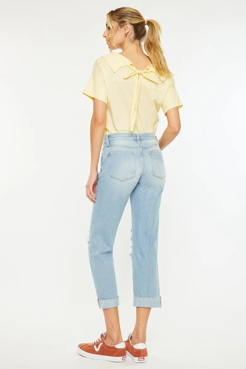 Light wash boyfriend jeans from side, mid-rise waist and distressed knee panels