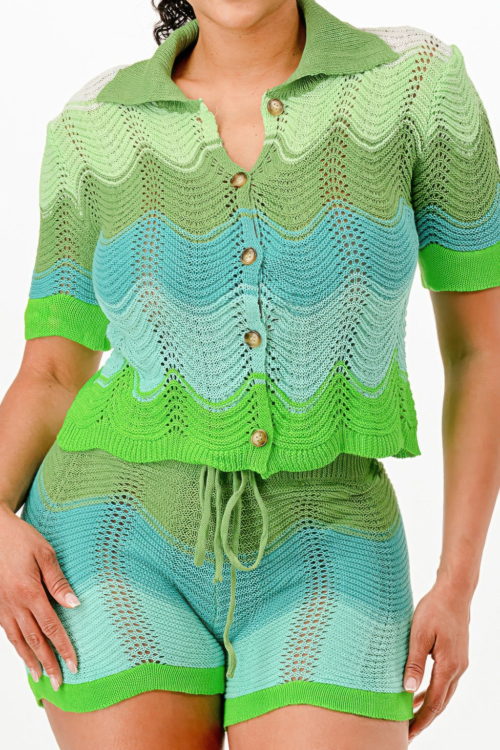 Close-up of knit cardigan crop top: green collar, blue wave pattern, gold buttons