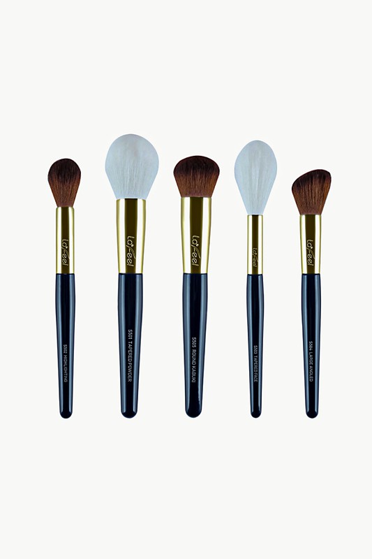 Five makeup brushes with white and brown bristles, gold caps, dark blue handles