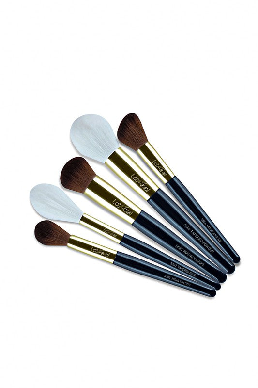 Five makeup brushes with mixed bristles and gold caps, dark blue handles