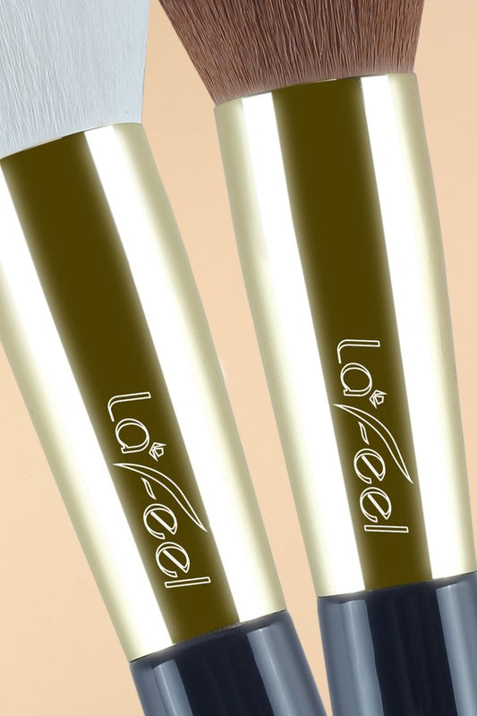 Close-up of two makeup brush handles with gold barrels, navy sleeves, printed logo