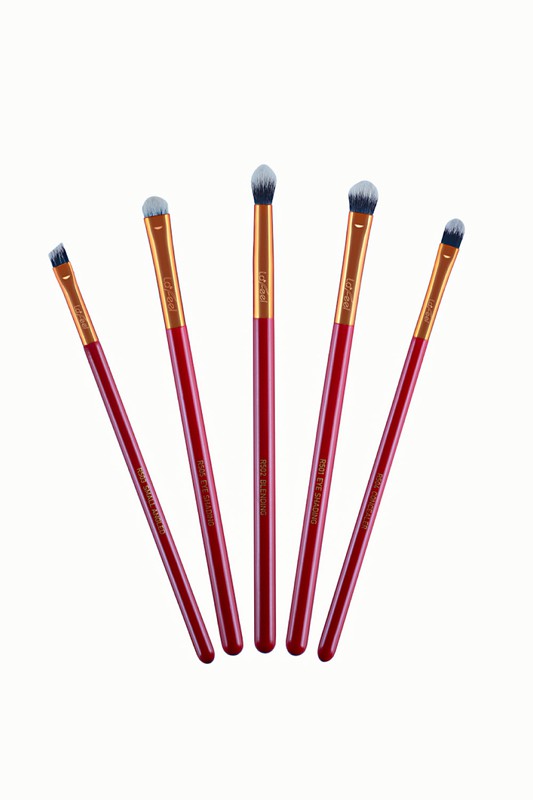 Five red eye brushes with tapered handles and soft blue bristle heads in a fan lineup