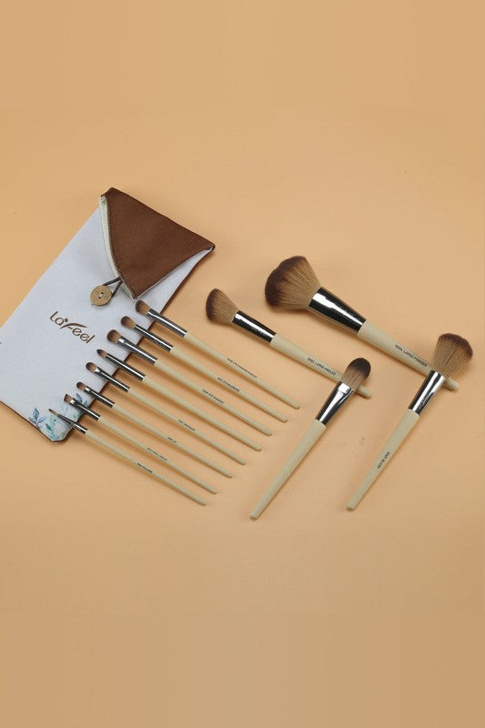 Beige-handled face and eye brushes with brown bristles laid out with pouch