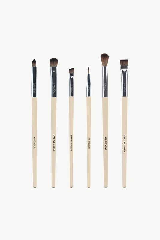 Six eye makeup brushes with beige shafts and brown bristles in a line