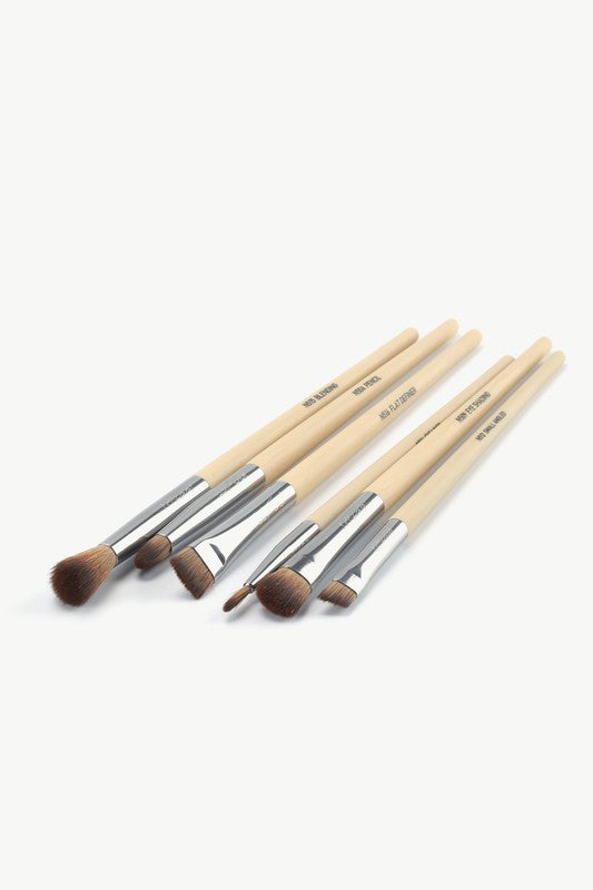 Eye brush lineup with beige handles and brown bristles, chrome ferrules visible
