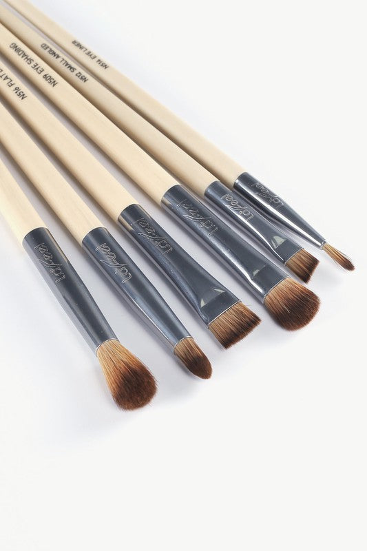 Close view of eye brushes: beige stems, dark glossy ferrules, brown bristle tips