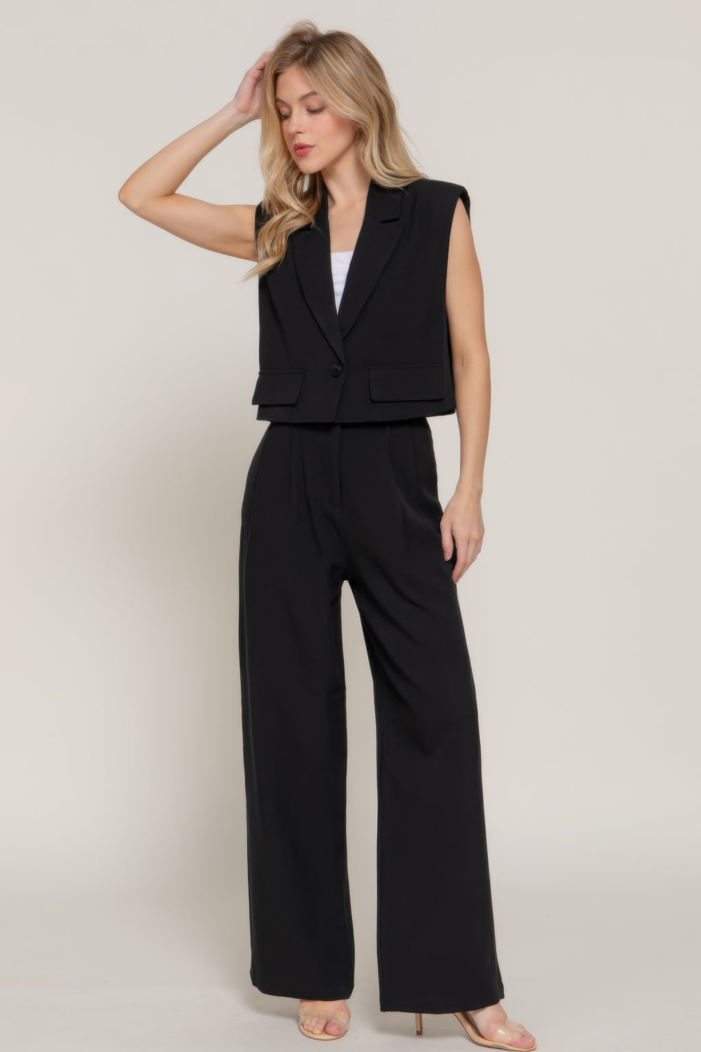Sleeveless black vest with lapel collar and welt pockets, straight hem