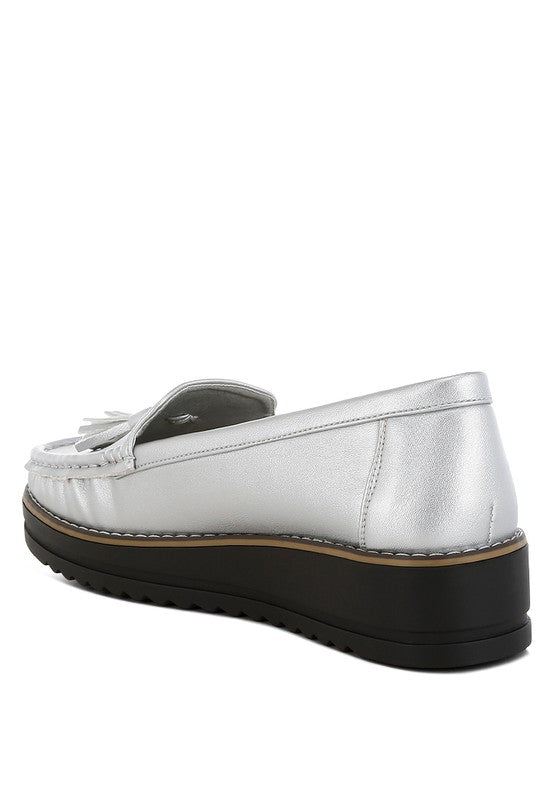 Silver metallic loafer side view, tassel accent, stitched vamp and black platform sole