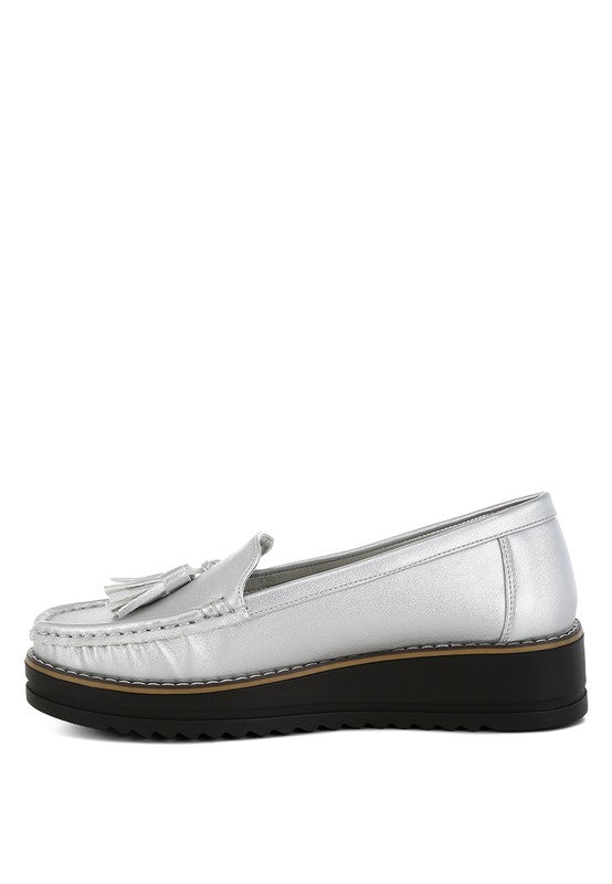Silver metallic loafer profile with tassel ornament and stitched moc toe, black sole