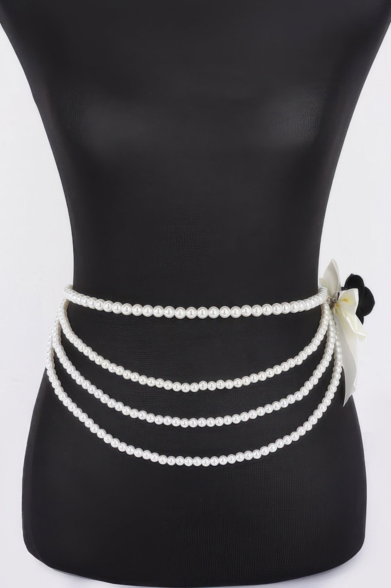 Black layered faux pearl ribbon belt with bow flower at right and three pearl rows