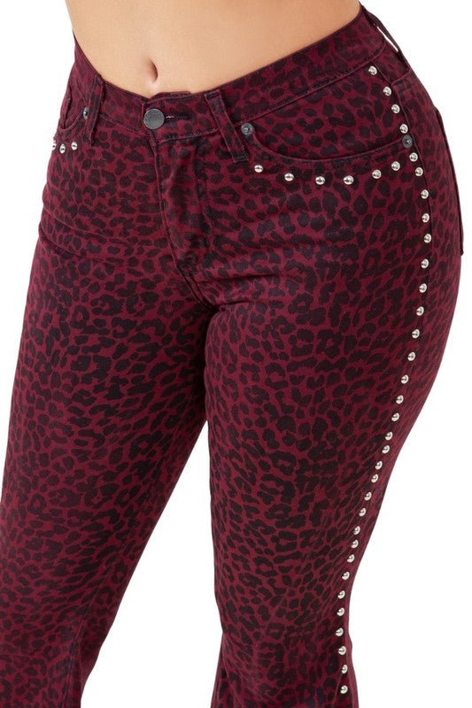 Burgundy leopard-print jeans with silver studs along the outer seam