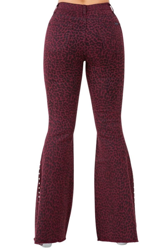 Back view: burgundy leopard-print flare jeans with stitched seams and silver studs