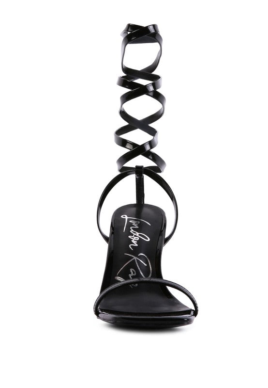 Black tie-up sandal with looped spiral straps over the foot and open square toe